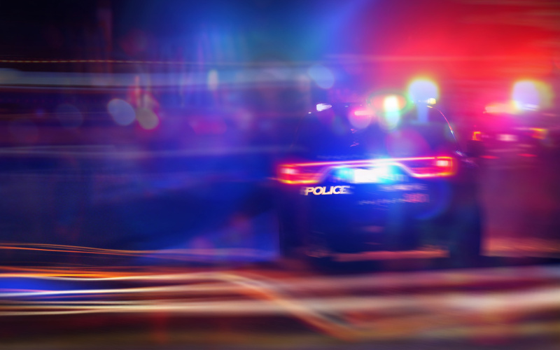 Police car speeding with lights on in response to a 911 emergency call, symbolizing law enforcement action, collision scenes, and accident-related investigations.