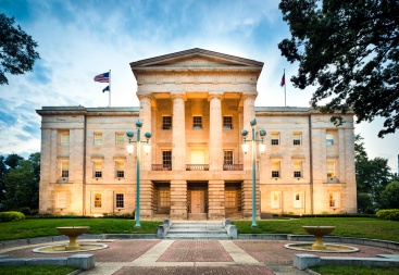 North Carolina State Capitol in Raleigh, where Senate Bill 452 (S.L. 2023-133) and Senate Bill 319 (S.L. 2024-29) were passed, changing UIM and liability auto insurance laws effective July 1, 2025.   Caption: The North Carolina State Capitol in Raleigh represents the legislative origin of sweeping changes to liability minimums and mandatory underinsured motorist (UIM) coverage, enacted under Senate Bill 452 and Senate Bill 319 and taking effect July 1, 2025. 